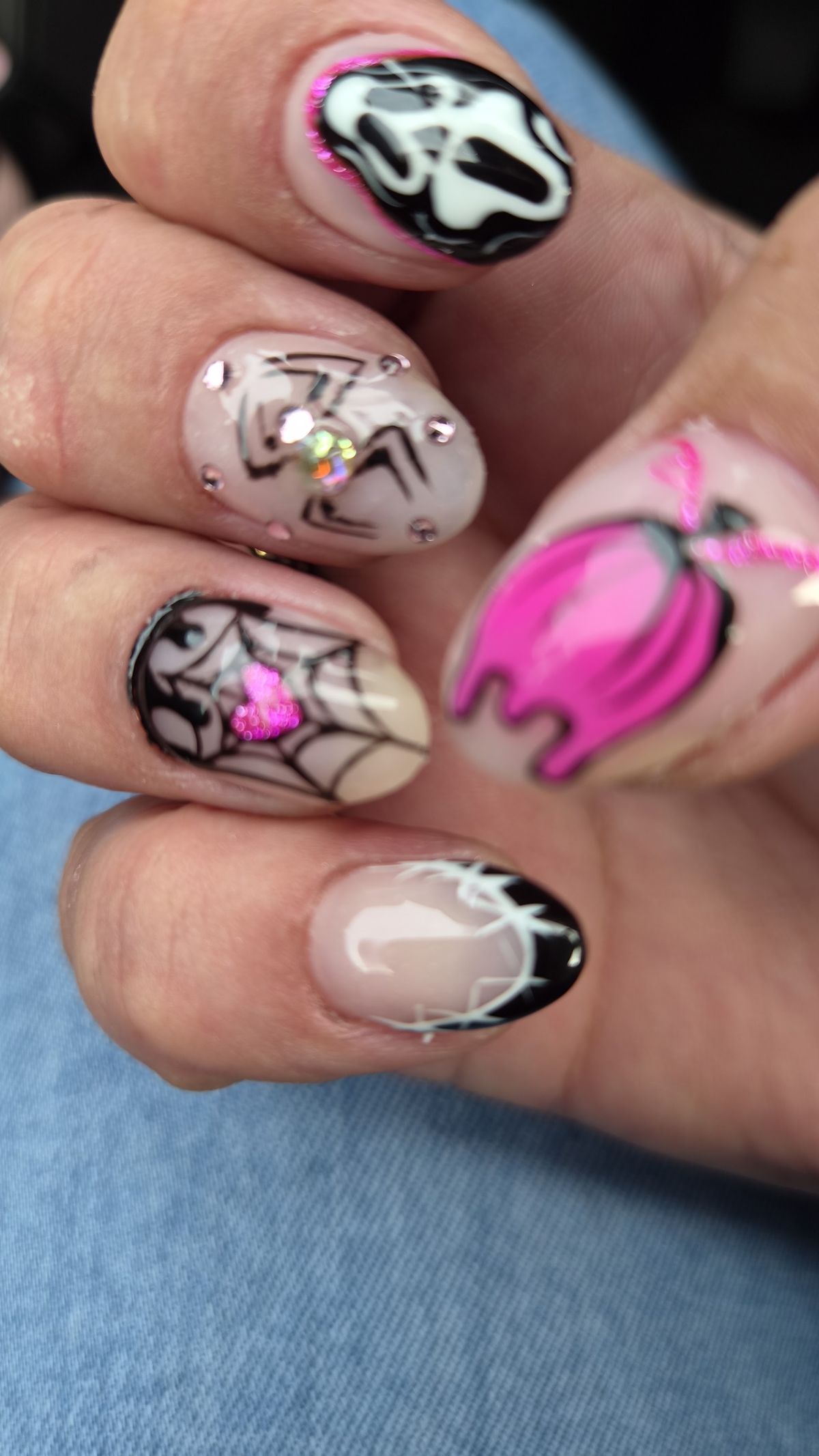 Nail art met Scream-masker, spin en roze druppels