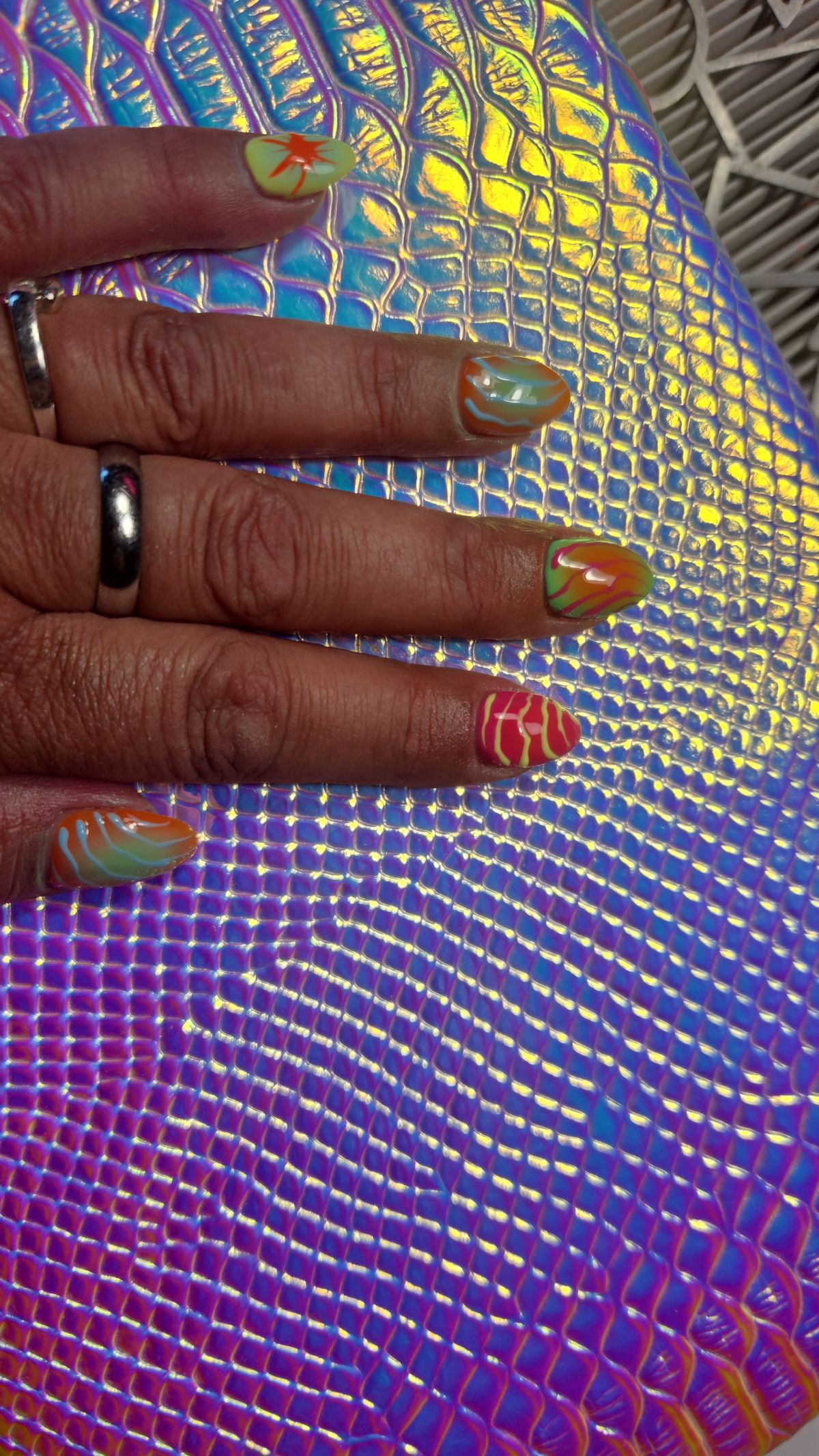 Nail art met oranje en groene swirls